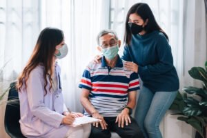 asian doctor visit examines senior man home doctor checking up consulting retirement health partienthospital services wearing mask protect covid19