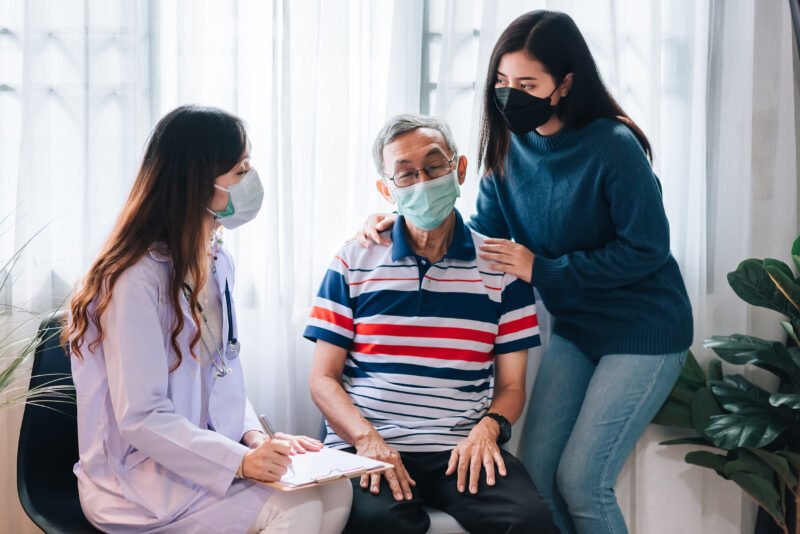 asian-doctor-visit-examines-senior-man-home-doctor-checking-up-consulting-retirement-health-partienthospital-services-wearing-mask-protect-covid19