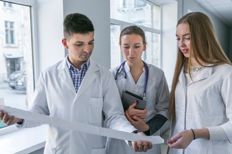 man-women-doctors-watching-cardiogram man-women-doctors-watching-cardiogram