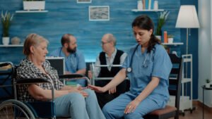 nurse consulting retired woman sitting wheelchair nursing home clinic medical assistant doing healthcare checkup with disabled old patient treatment recovery from pain