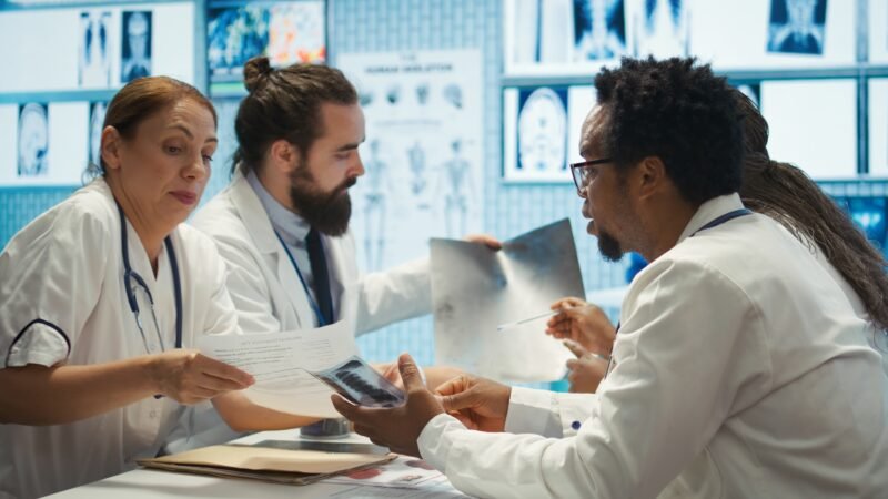 Radiologists and specialists examine x rays and discuss medical care Radiologists and specialists examine x rays and discuss medical care