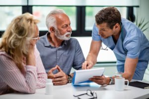 serious doctor discussing with senior couple about their medical documents appointment clinic 1 1