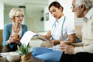 young healthcare worker senior couple analyzing medical test results home visit
