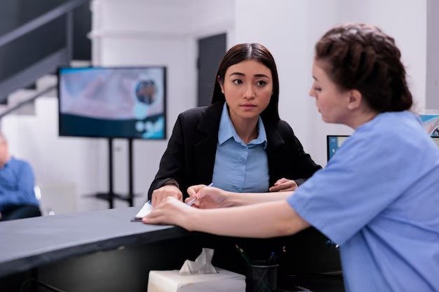 imgi 56 nurse showing medical report receptionist discussing expertise checkup visit examination hospital waiting room worker helping